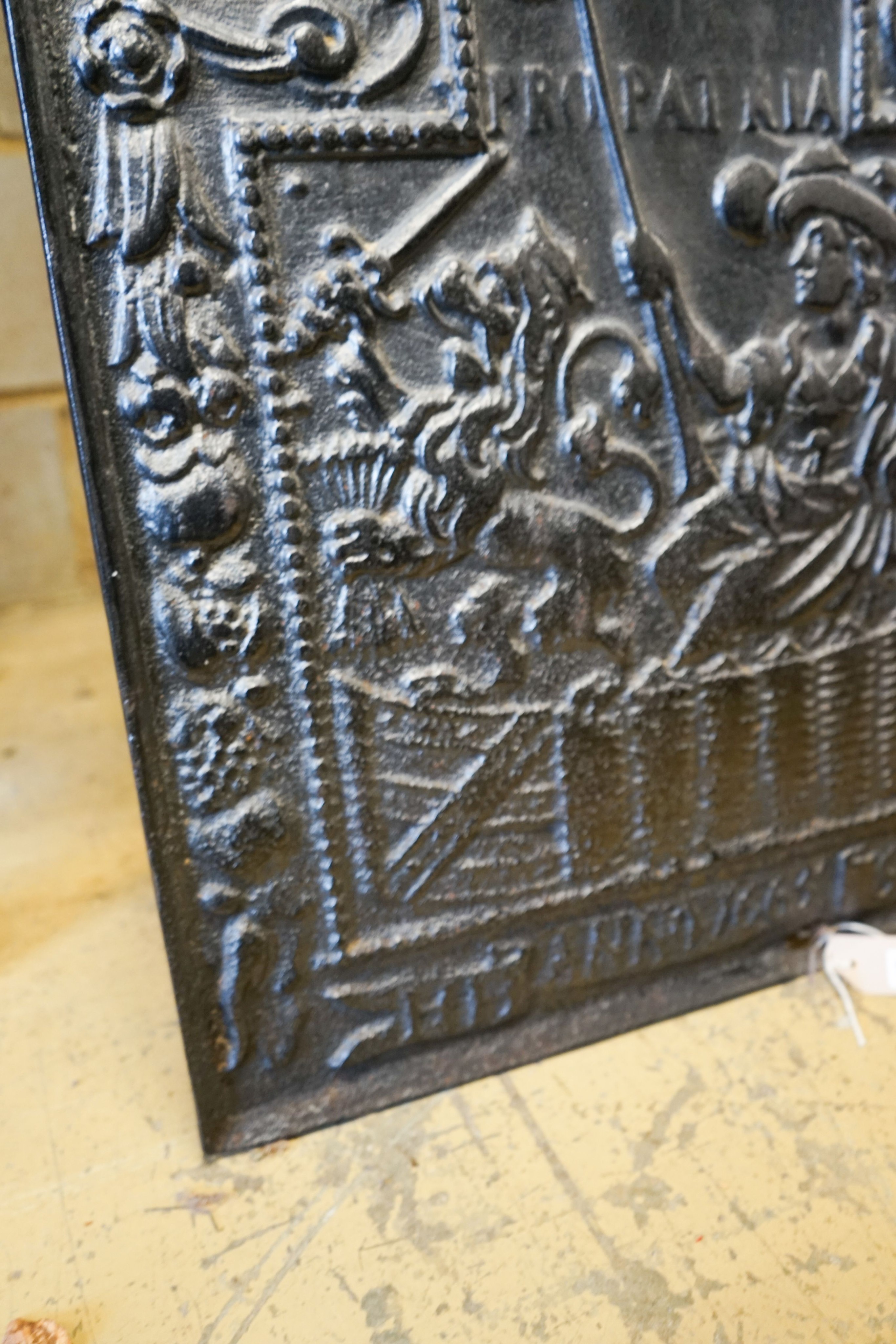 A cast iron fireback inscribed 